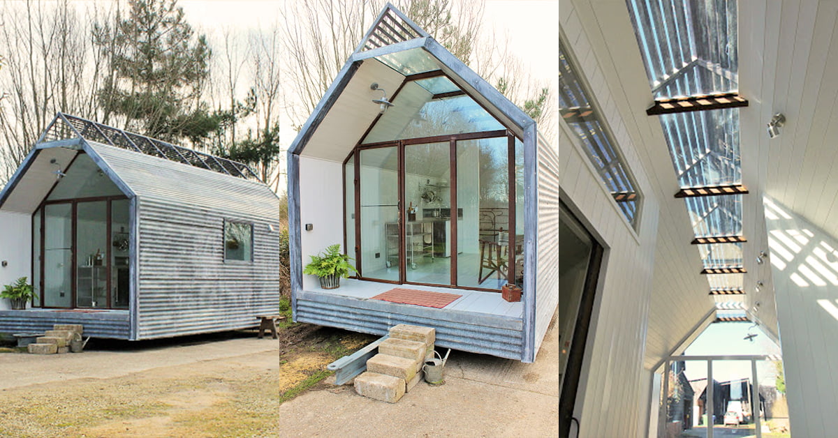 A modern tiny house with a gabled roof and large glass doors, perfect for a garden office. The exterior is clad in horizontal wood siding, and there's a small set of concrete steps leading up to the entrance. Inside, there's a lofted ceiling with skylights and a minimalistic interior design. - a room in the garden