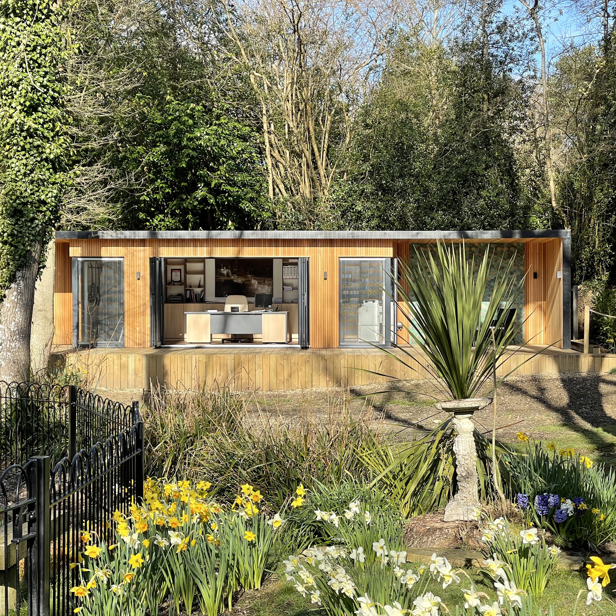 Large bespoke garden office exterior with roof overhang and decking