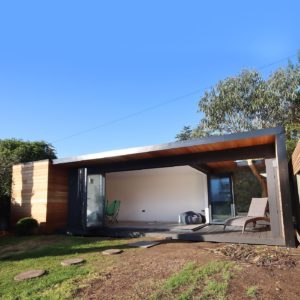Unique designer garden room with roof overhang and sitting area